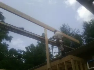 Carpenter setting a ridge beam over a new addition frame — Ice Dam Removal by Roofing Brothers in Montevallo