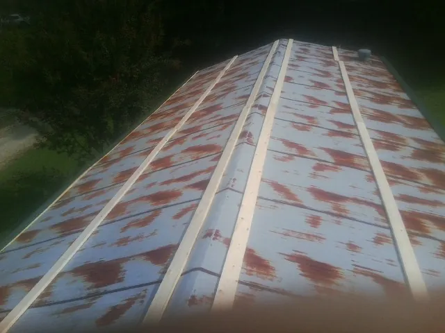 Rusted metal roof panels with new wood purlins before replacement — Storm Damage Roof Repair in Montevallo by Roofing Brothers
