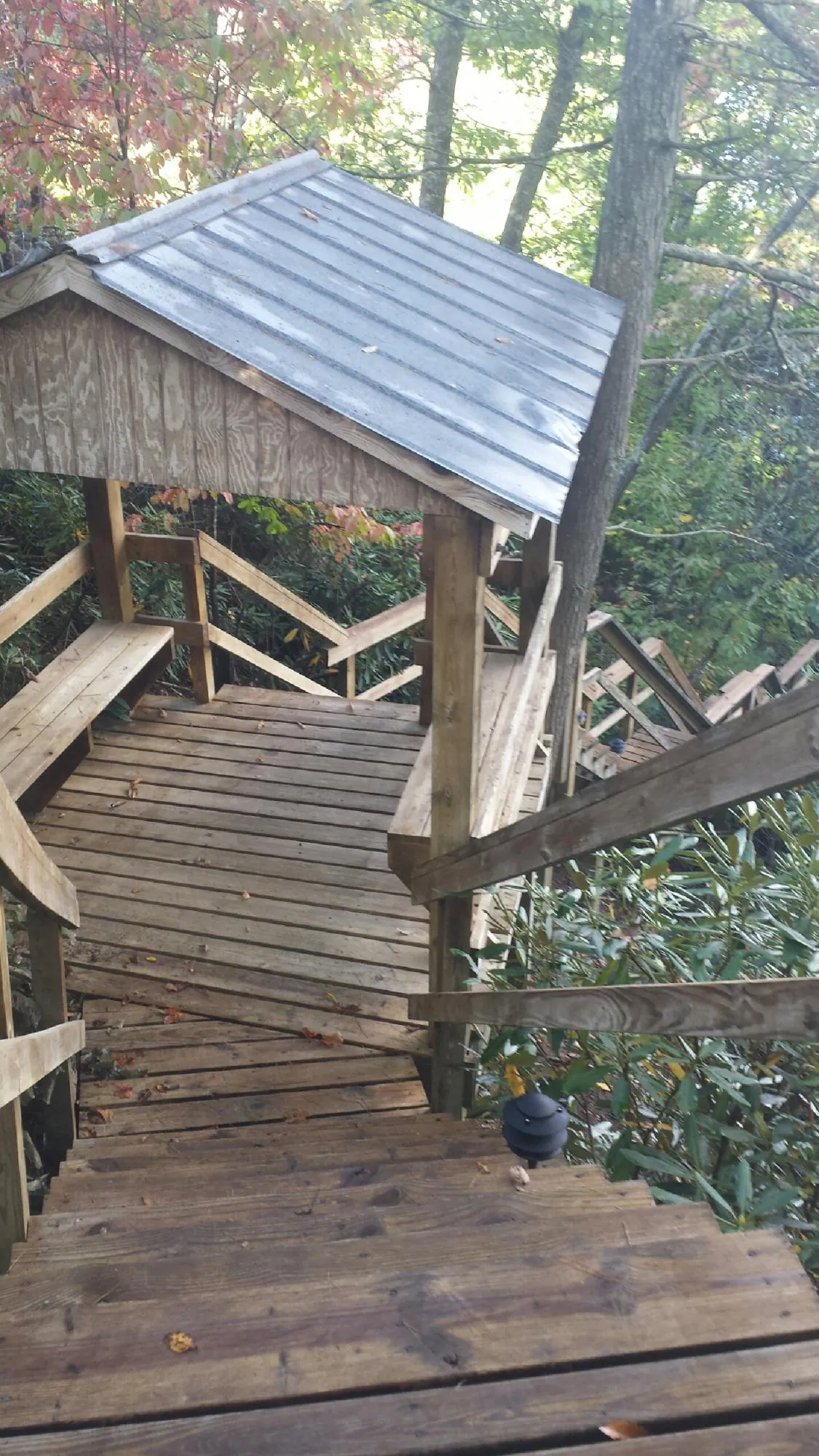 Metal roofed shelter over wooden steps on a wooded walkway — Skylight Repair & Installation work by our crew in Montevallo