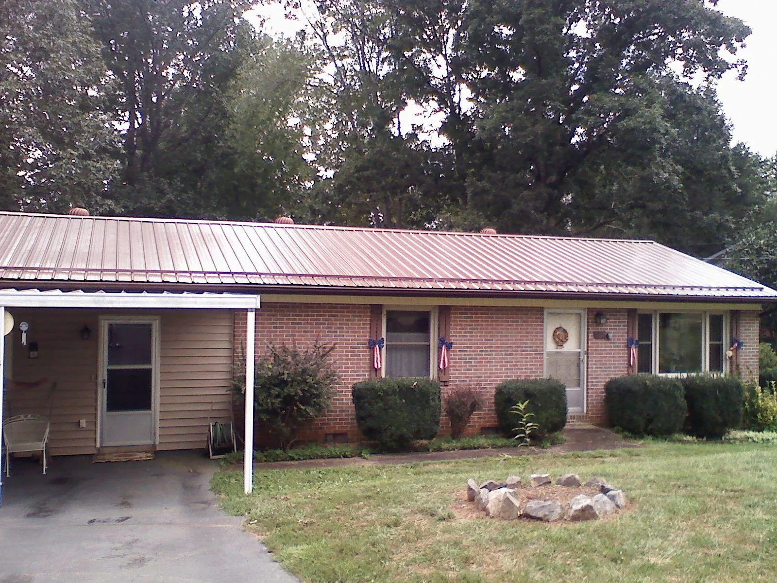 Bronze metal roof and carport on a brick ranch home — Roof Repair work by our crew in Montevallo