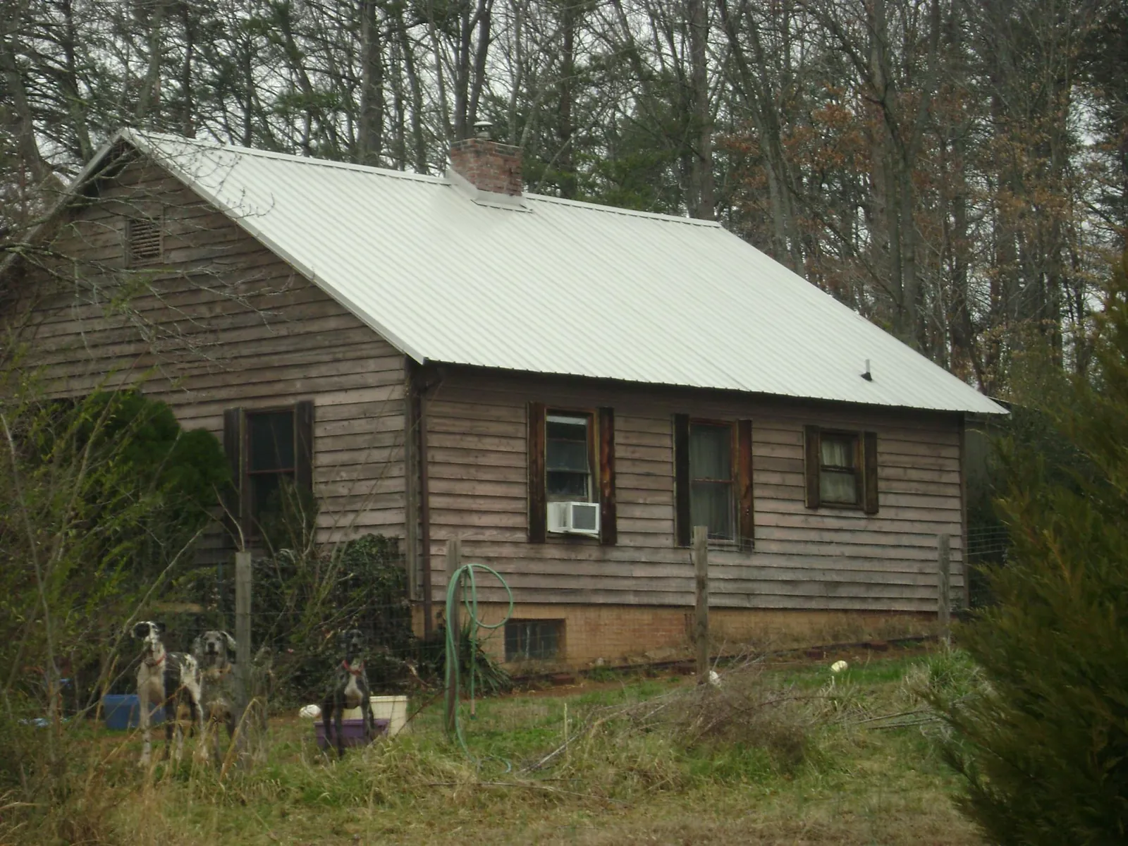 White metal roof on an old wood sided farmhouse, from a Metal Roof Installation job in Montevallo